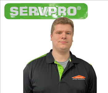 Joshua, SERVPRO employee, in uniform, against a white backdrop and green SERVPRO sign